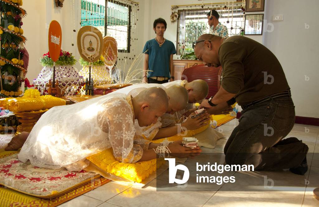 Thailand: Thai Buddhist ordination ceremony, Chiang Mai. The nakor monks-to-be are presented with money and their wrists are tied with white thread by relatives and well wishers at the sukhwan nakceremony