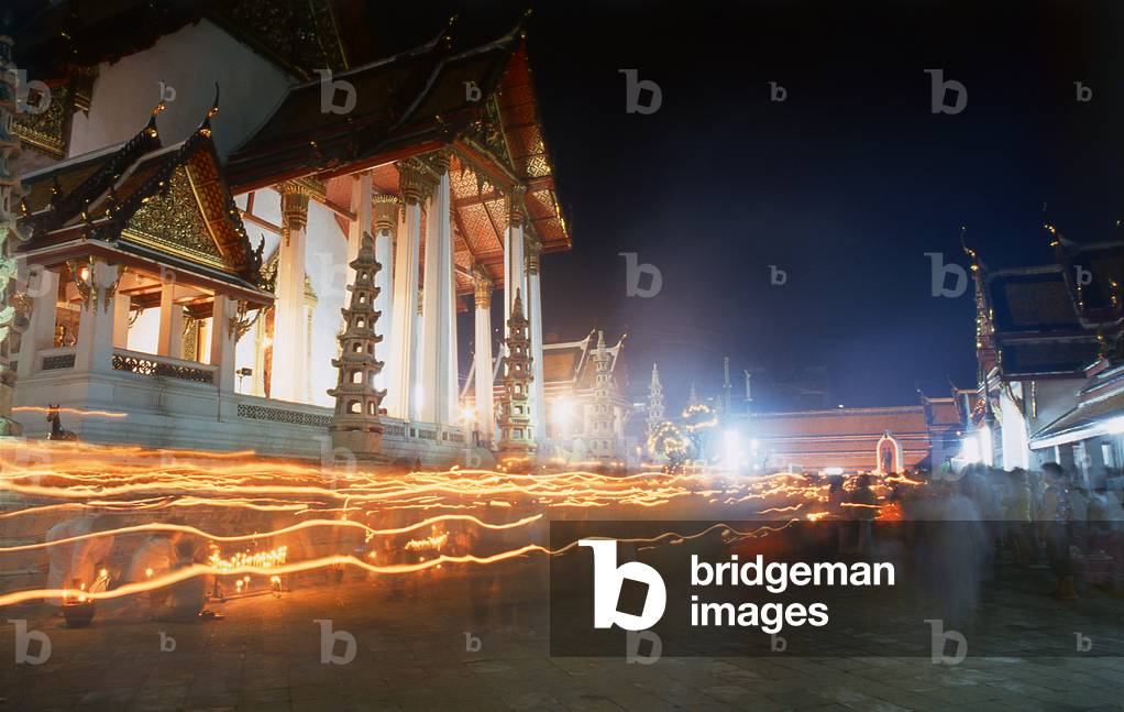 Thailand: A procession of Thai Buddhists holding candles and circumambulating the viharn at Wat Suthat, Bangkok, for the Visakha Puja Festival