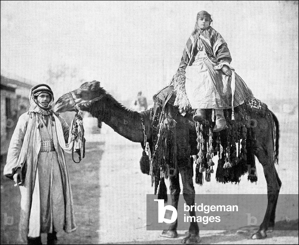 Syria: Bedouin woman riding a camel led by her husband, c.1905