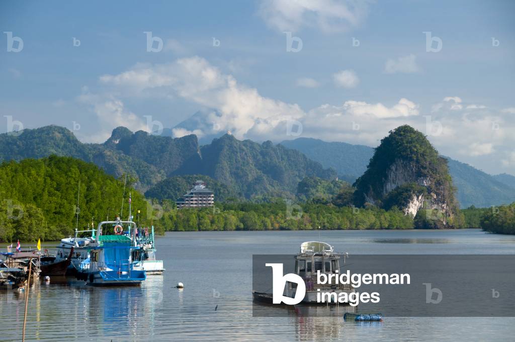 Thailand: Khao Khanap Nam outcrop and the Seated Buddha atop the peak next to the Tiger Temple from the Krabi Town waterfront, Krabi Province, southern Thailand