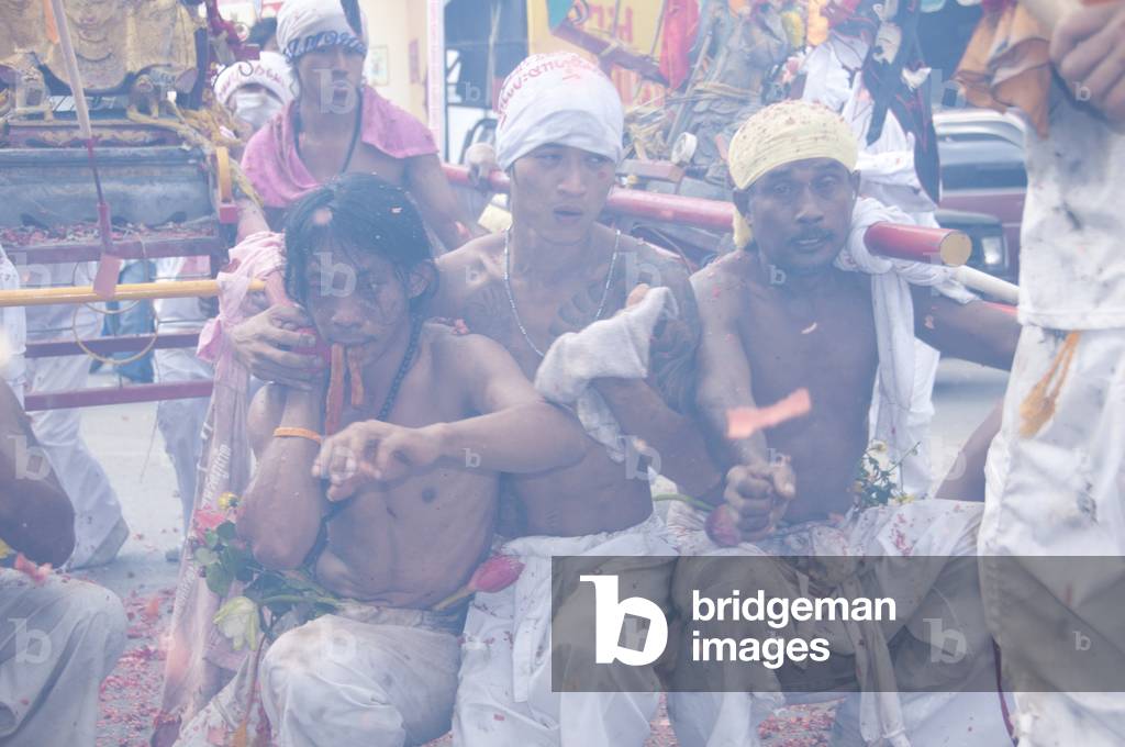 Thailand: Shrine bearers enveloped in smoke from exploding firecrackers appear almost dazed, Phuket Vegetarian Festival