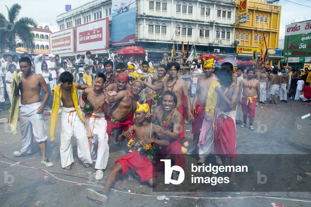 Thailand: Firecrackers explode over shrine bearers and they are quickly enveloped in thick smoke, street procession, Phuket Vegetarian Festival
