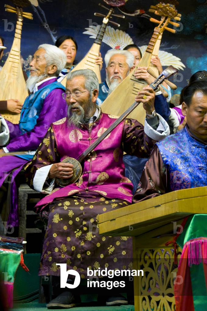 China: A man plays a sanxian, the Naxi (Nakhi) Folk Orchestra, Naxi Orchestra Hall, Lijiang Old Town, Yunnan Province