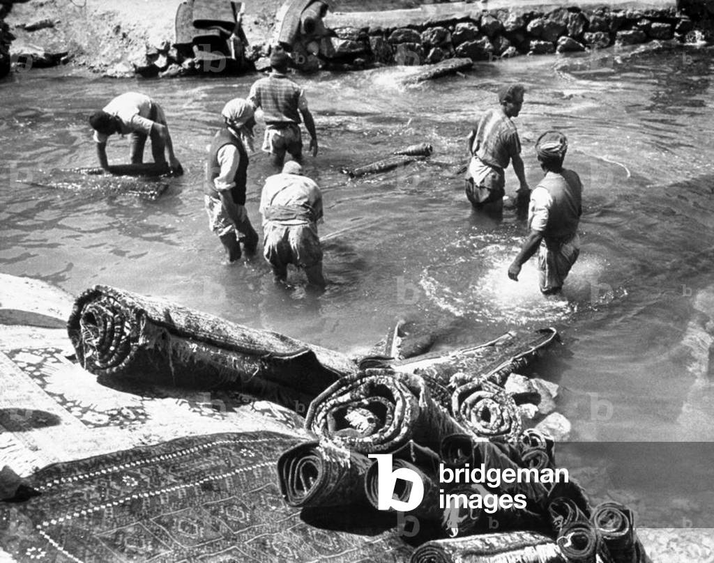 Iran / Persia: A group of men washing Persian rugs in a river, northern Iran, c. 1930