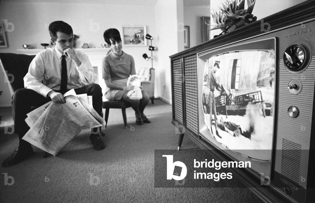 USA / Vietnam: 'War Comes to the Living Room'. An American couple watching film footage of the Tet Offensive on a television in their living room, Warren K Leffler, 1968