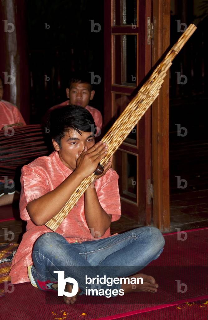 Laos: A man playing a khene (kaen), a traditional Lao instrument made of bamboo, Luang Prabang