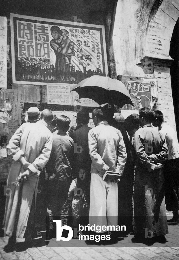 China: A crowd gathers to read news on a billboard in Simao, Yunnan Province, in 1920.