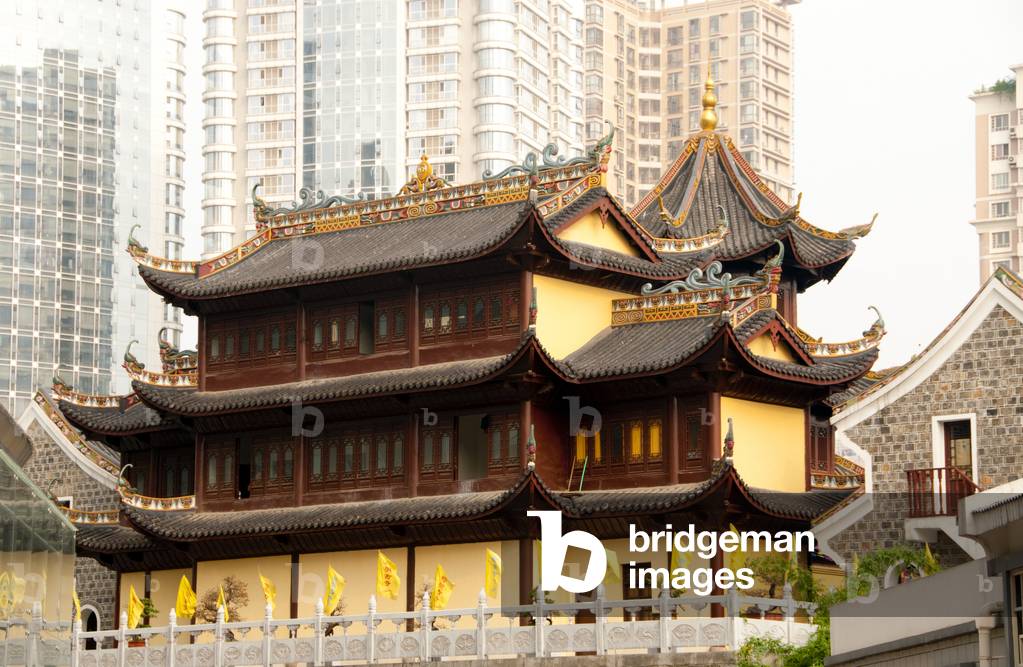 China: Modern buildings loom over Ming-era Buddhist Qianming Temple, Guiyang, Guizhou Province