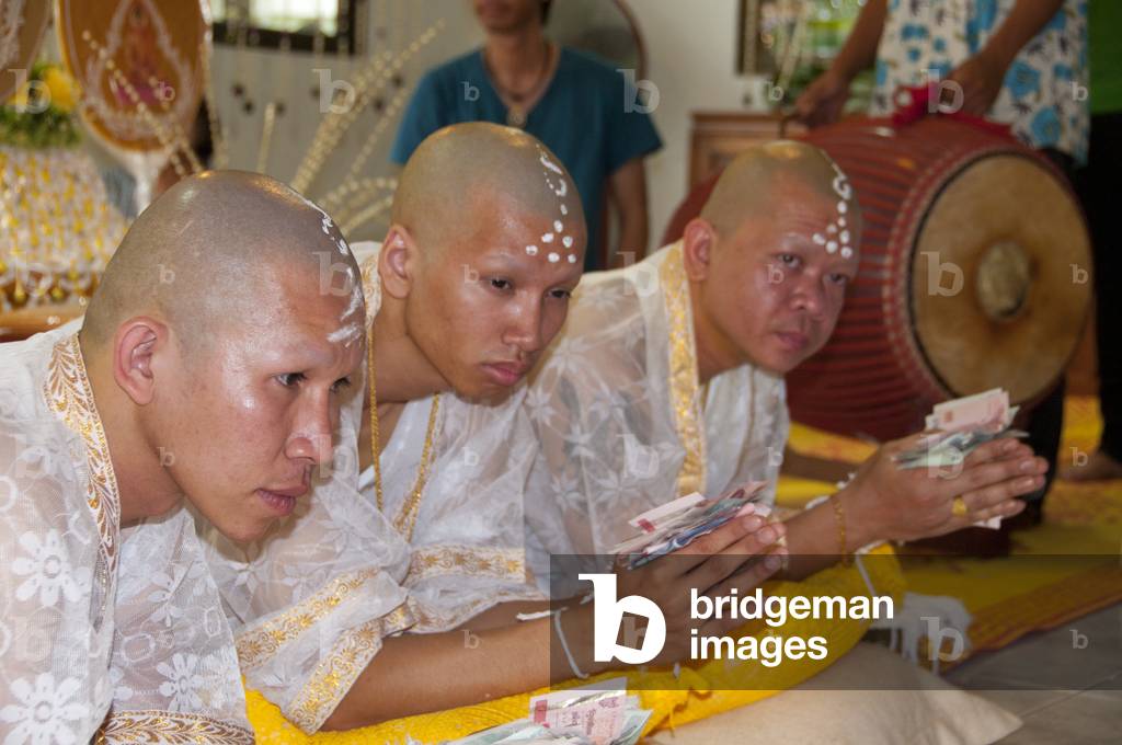 Thailand: Thai Buddhist ordination ceremony, Chiang Mai. The nakor monks-to-be are presented with money and their wrists are tied with white thread by relatives and well wishers at the sukhwan nakceremony