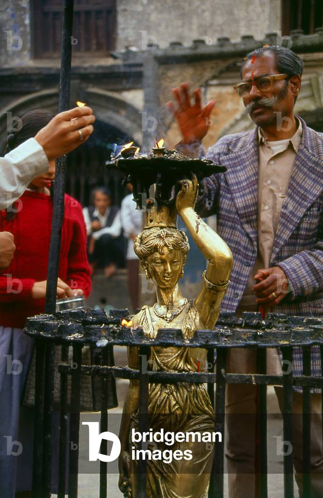 Nepal: Worshippers at a European-style statue, originally from the old Rana Palace, Kathmandu