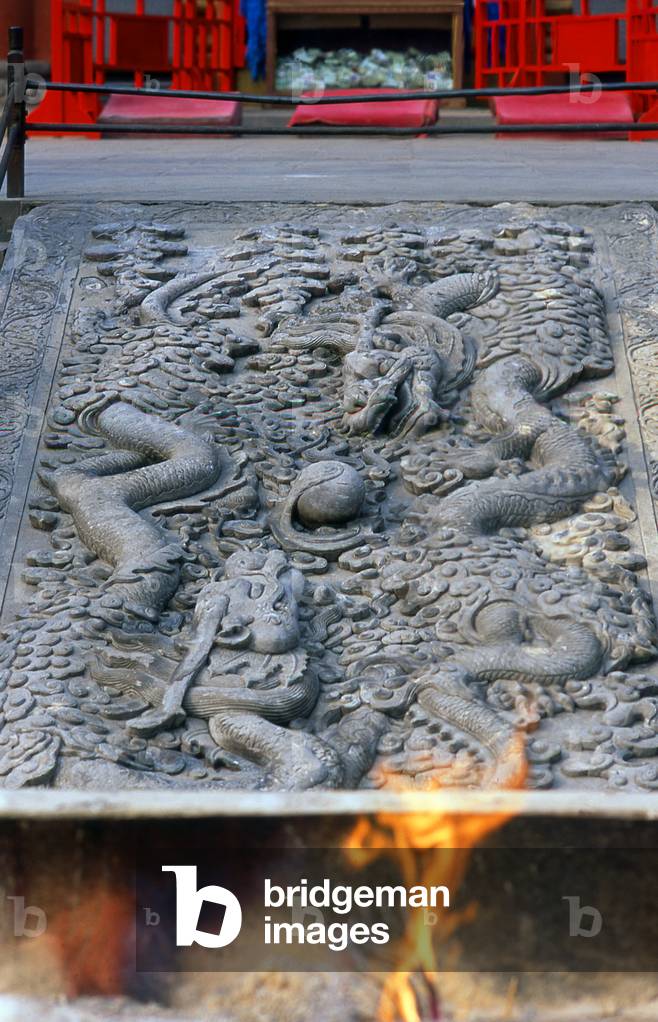 China: A flame burns next to 'Two dragons playing with a pearl' (a common theme in Chinese temples) in front of the main temple building at the Puning Temple (P?níng Sì) or Temple of Universal Peace, Chengde, Hebei Province
