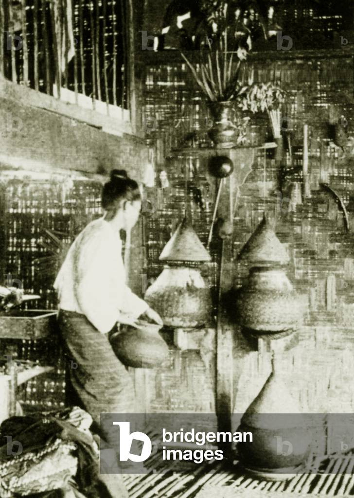 Burma: A woman places a jug of drinking water on the floor, c.1892-96.