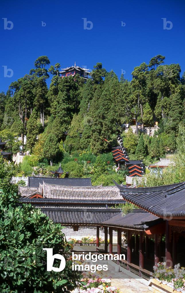 China: Mu Family Mansion (Mushi Shisifu) with Wanggu Lou (Looking at the Past Pavilion) atop Shizi Shan in the background, Old Town, Lijiang, Yunnan Province