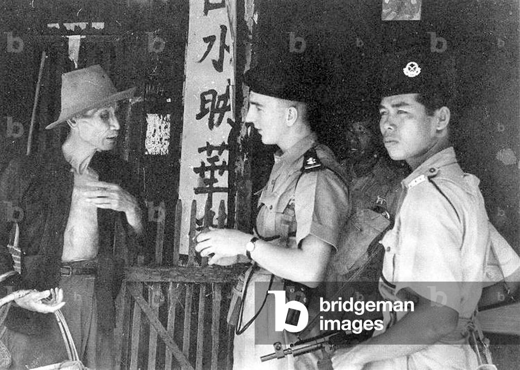 Malaysia: British and Malay military police check the credentials of an elderly Sino-Malay during the 'Emergency', April 1949.
