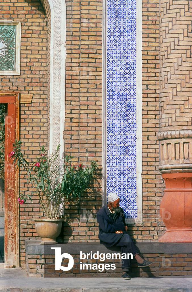 China: Uighur man at the front entrance to the Altyn Masjid (Altun Mosque), Yarkand, Xinjiang Province