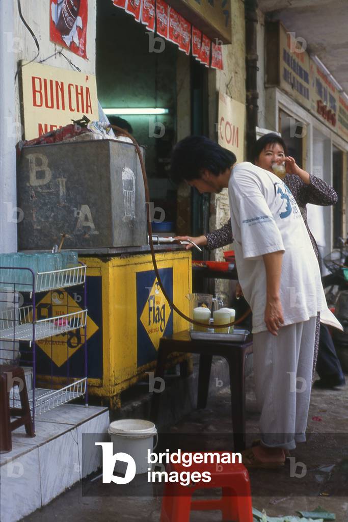 Vietnam: Filling beer glasses at a bia hoi ('fresh beer') pavement bar, Hanoi