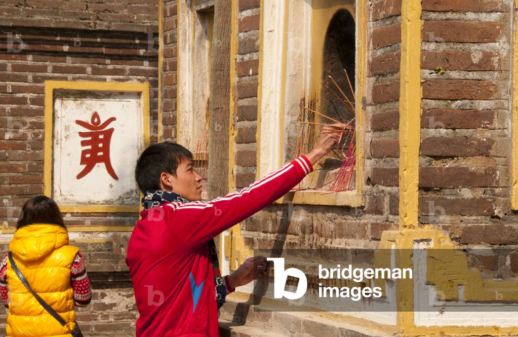 Vietnam: Placing incense sticks at the Tran Quoc Pagoda (Tran Quoc Buddhist temple), Ho Tay (West Lake), Hanoi