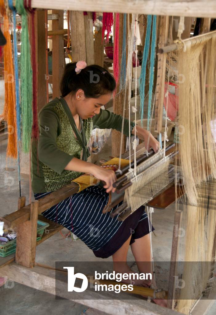 Laos: A young weaver in a village near Luang Prabang