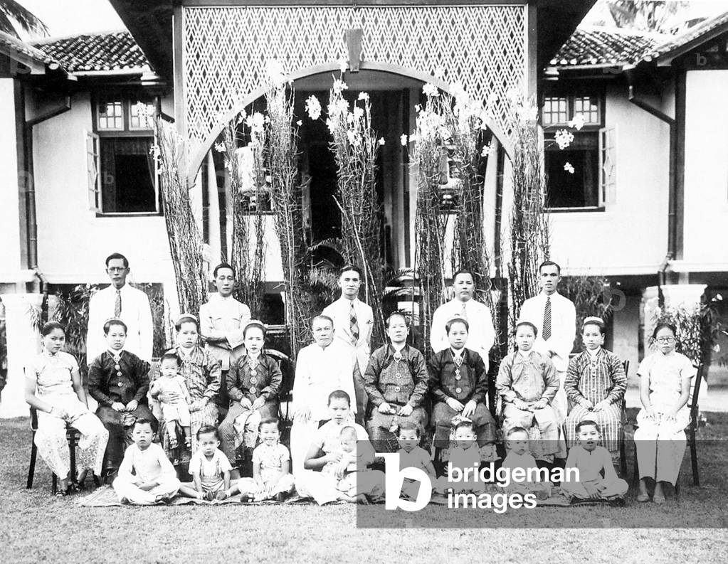 Malaysia / Singapore: An extended Peranakan family posing in the garden of their house, early 20th century