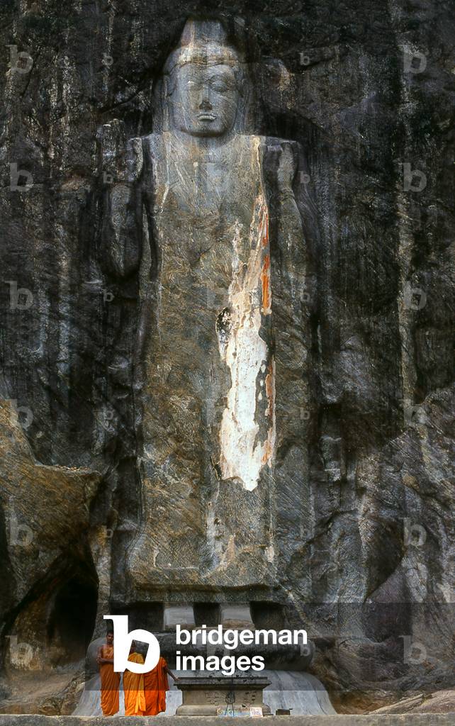 Sri Lanka: Buddhist monks in front of a 1000 year old carved stone 16m Buddha, Buduruvagala (photo)