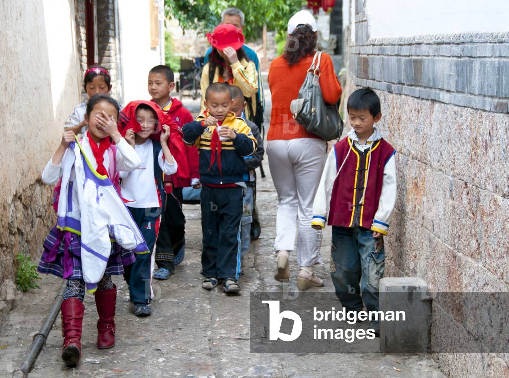 China: School children on a Lijiang Old Town back street, Yunnan Province