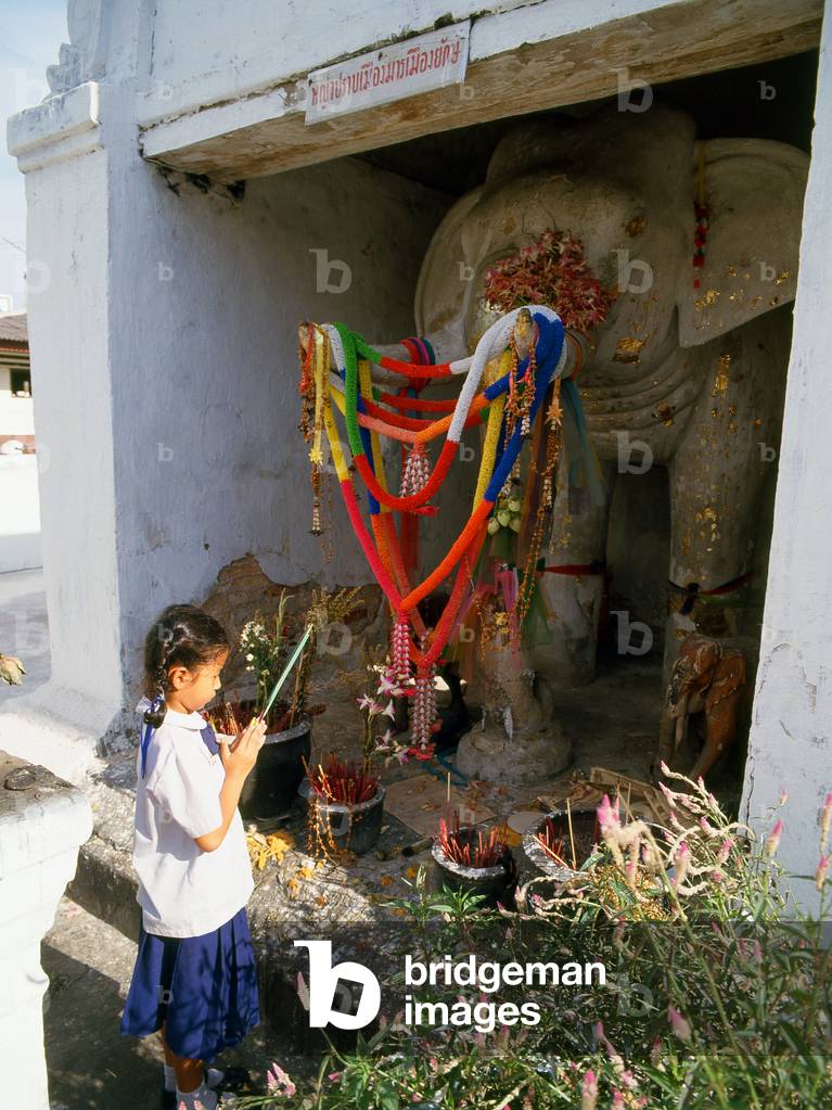Thailand: Young girl paying respects at the White Elephant shrine near Chang Phuak Gate, Chiang Mai, Northern Thailand
