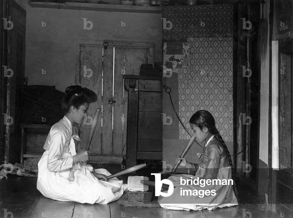 Korea: Two women using heavy pangmangi batons to smooth clothing, c. 1910.