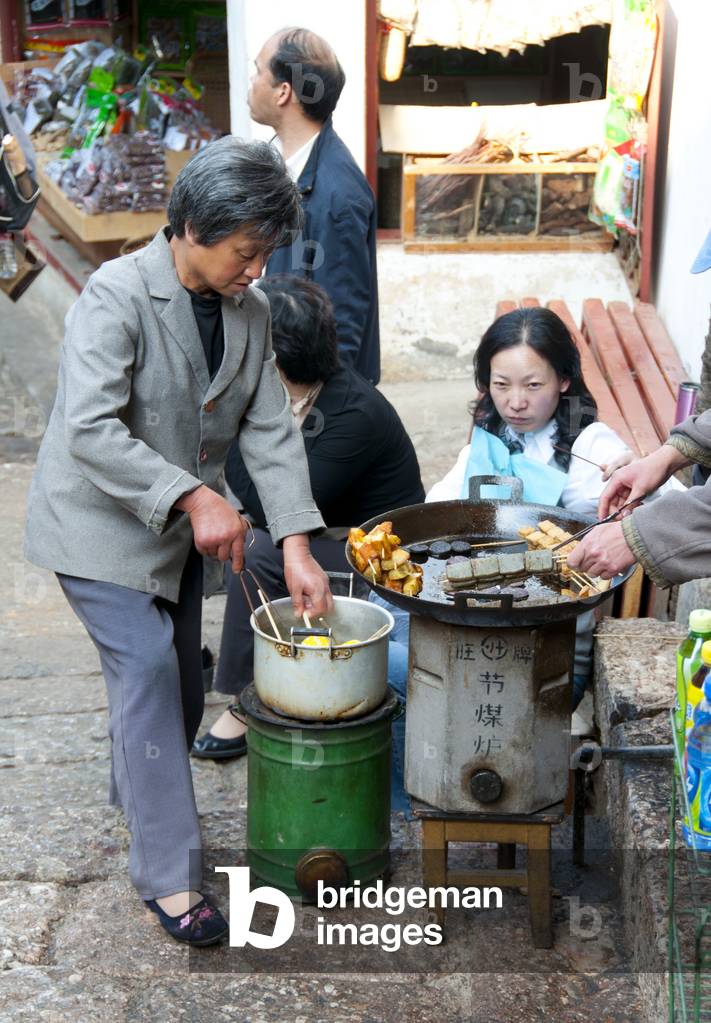China: Deep-fried tofu and other delicacies on a side street in Lijiang Old Town, Yunnan Province