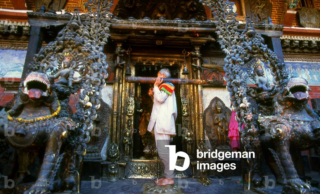 Nepal: A priest 'waking up' the deity at the Rudra Varna Mahavihar temple, Patan, Kathmandu Valley (1998)