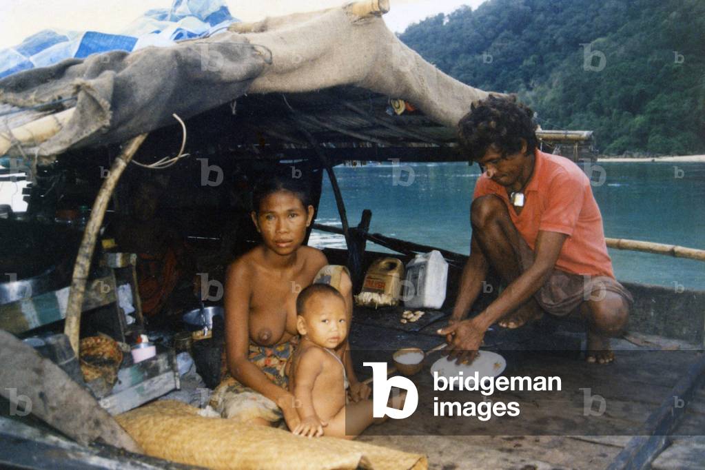 Thailand: A Chao Thalae 'Sea Gypsy' family preparing food aboard their boat, c. 1960