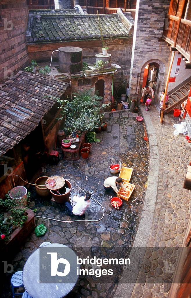 China: Family life in the inner courtyard at Zhenchang Lou Hakka Tower near Hukeng, Yongding County, Fujian Province