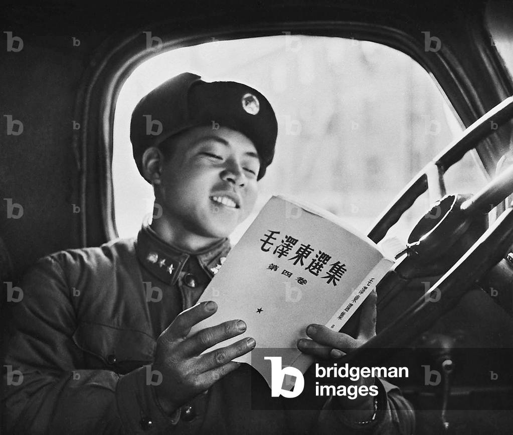 China: Communist role model Lei Feng reading Chairman Mao, c. 1963