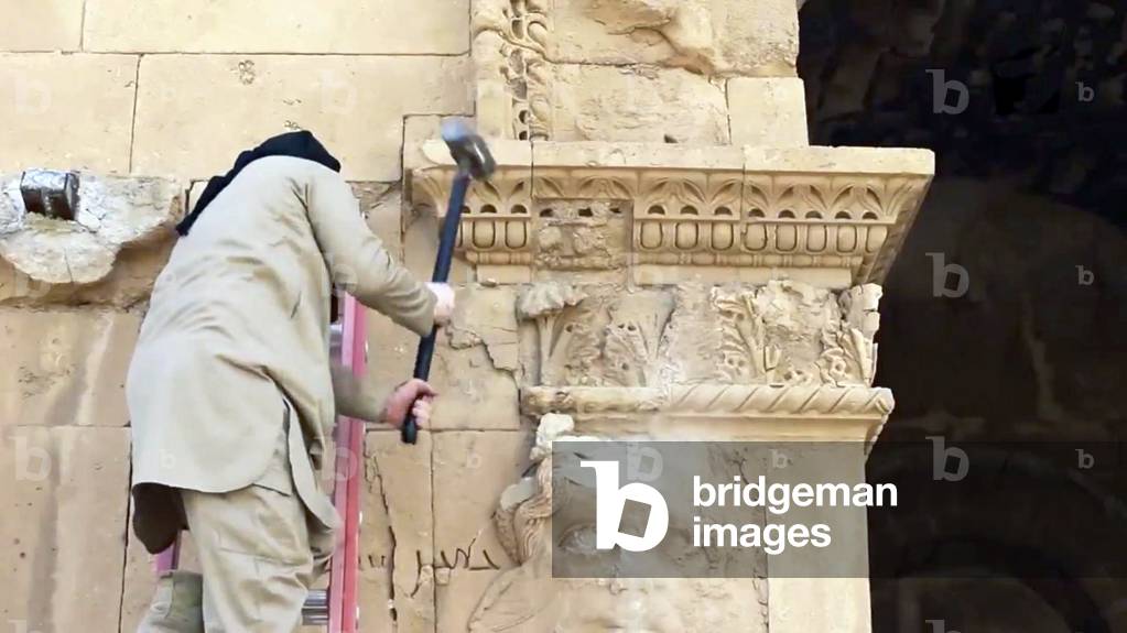 Islamic State / Syria: An ISIL militant uses a sledgehammer to destroy part of a Roman Era arch at Palmyra, April 2015