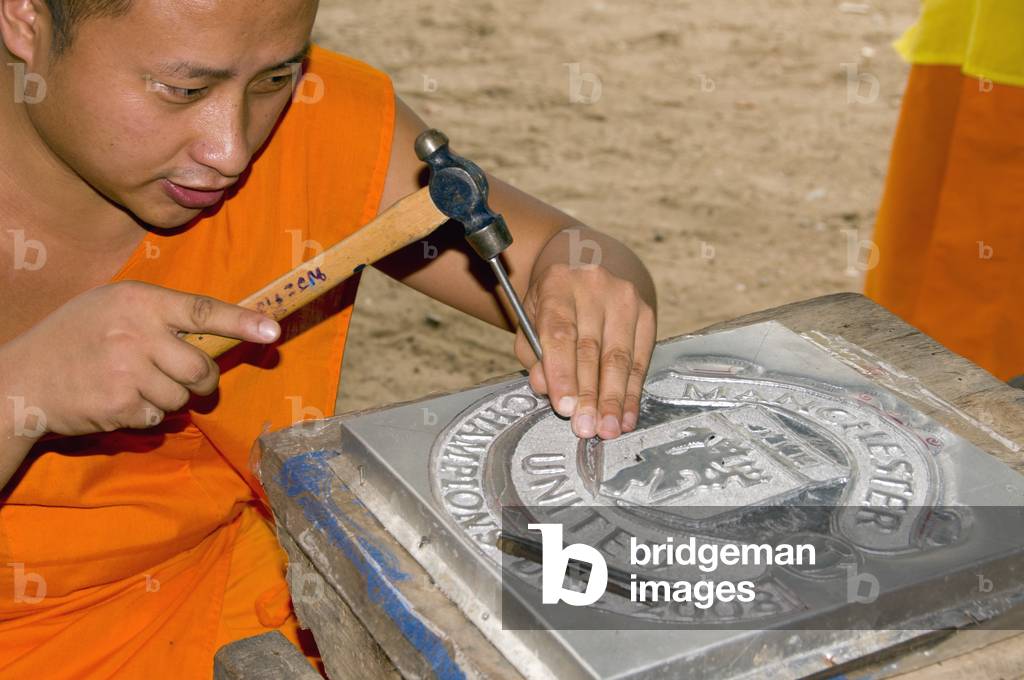 Thailand: Monk working on a silver Manchester United shield, Wat Meun San, Chiang Mai, northern Thailand