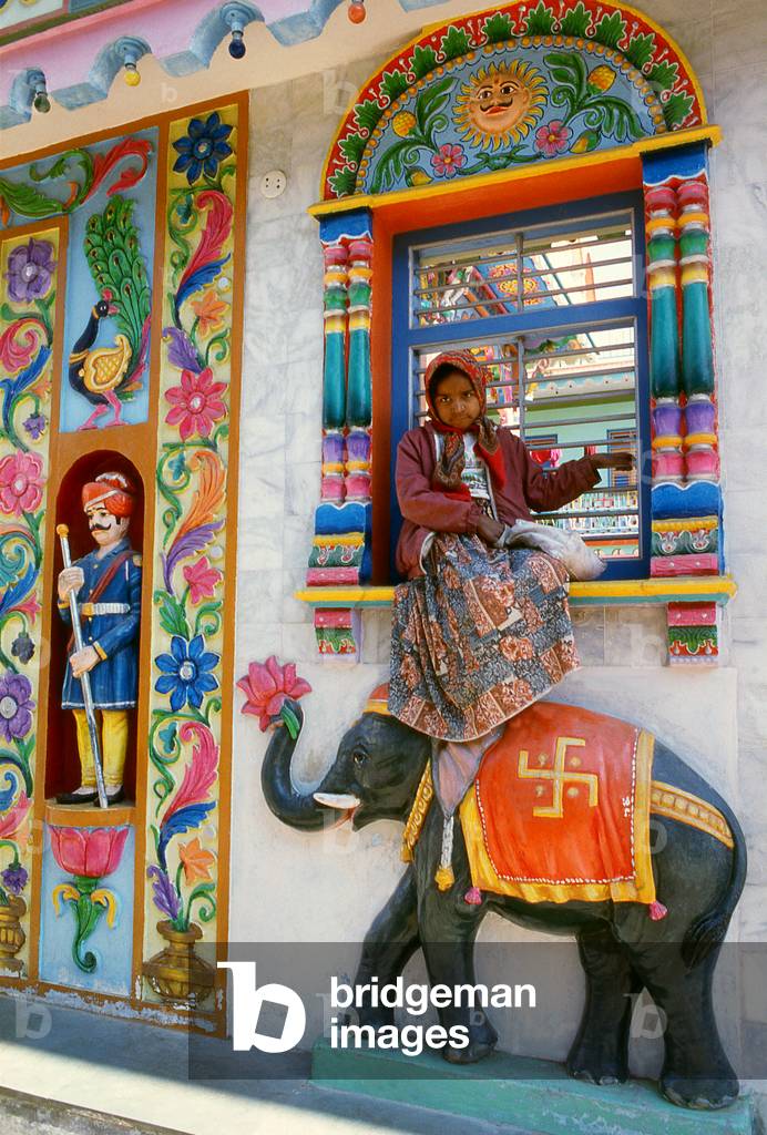 India: A girl sits on a window ledge at a Hindu temple in Kutch, Gujarat State