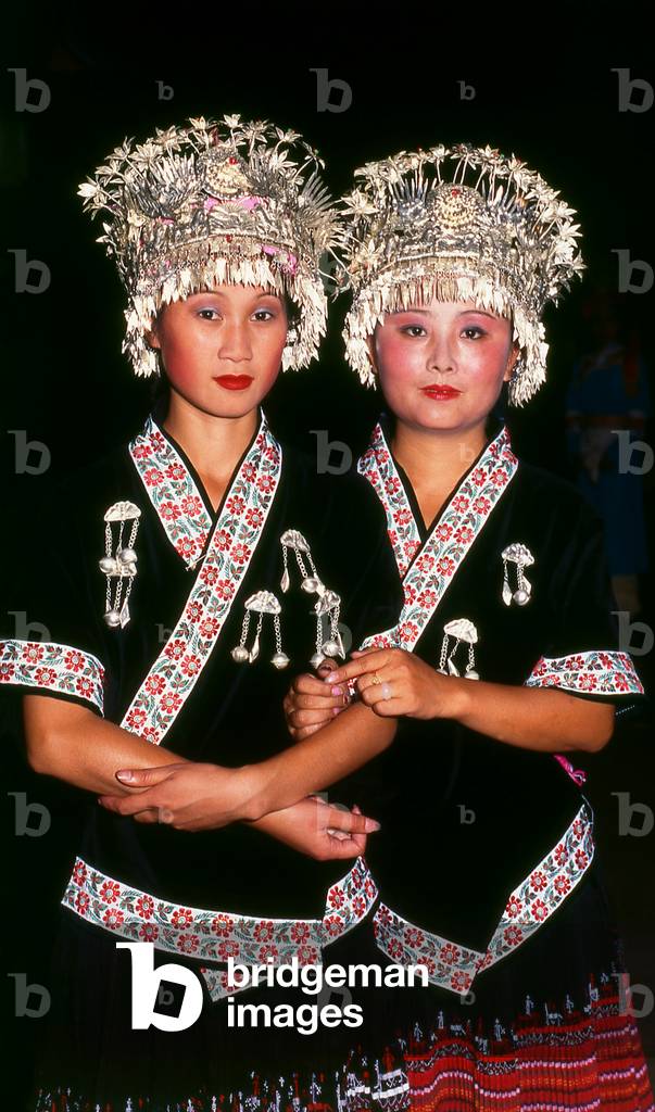 China: Young Miao women with distinctive silver headdresses at a festival near Guiyang, Guizhou Province