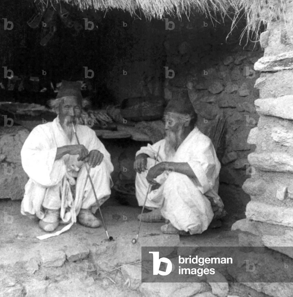 Korea: Two elderly Korean peasants at a village store in the northern suburbs of Seoul, early 20th century