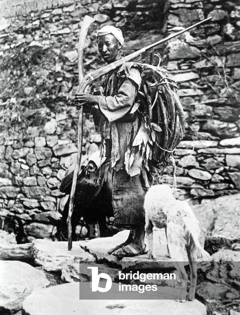 Tibet / China: a Khampas ferry man, photographed in 1937, carrying a walking stick, a rudimentary rifle and a rattan cable which was used to assist people across the Mekong River.