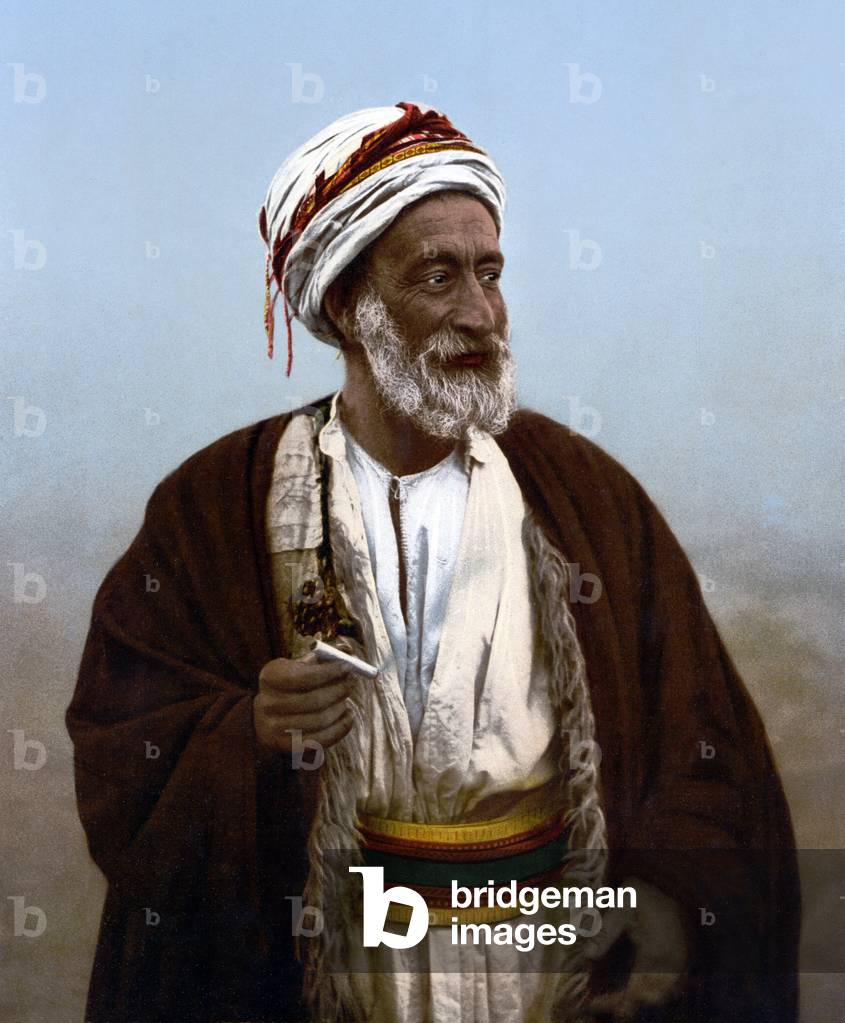 Palestine: A Palestinian patriarch and village chief. Hand coloured photographic print, early 20th century