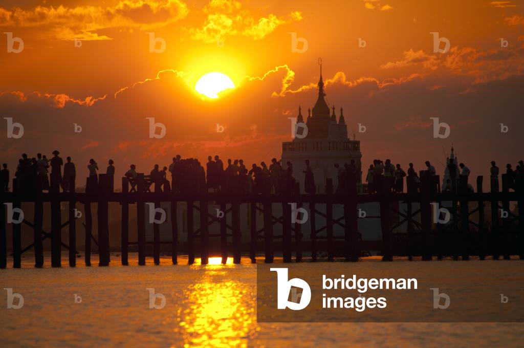Burma / Myanmar: People gather to watch the sunset on the U Bein Bridge, the longest teakwood bridge in the world, Taungthaman Lake, near Amarapura, Mandalay