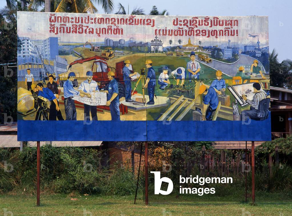 Laos: Construction and Industry in Laos. Revolutionary Socialist realist-style political poster on the streets of Vientiane
