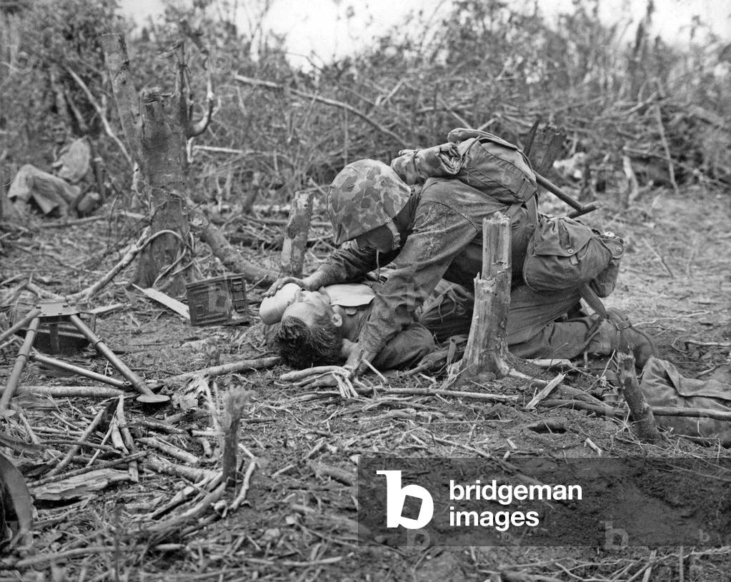 Japan / USA: A wounded marine is given a drink of water from the canteen of a comrade, Battle of Peleliu, September-November 1944
