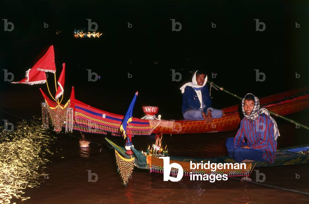 Laos: Racing boats return home for the night as the sun sets over the Mekong River, Bun Nam festival, Vientiane