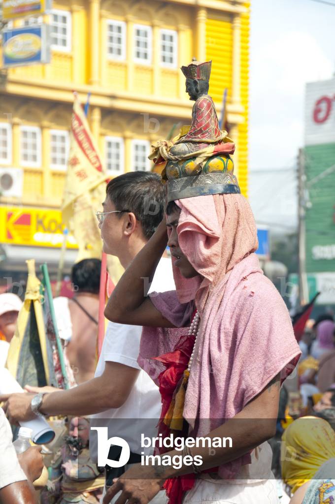 Thailand: A devotee or 'Ma Song' carries a temple god on his head in the parade, Phuket Vegetarian Festival