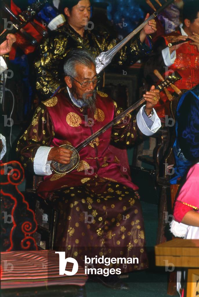 China: A man plays a sanxian, the Naxi (Nakhi) Folk Orchestra, Naxi Orchestra Hall, Lijiang Old Town, Yunnan Province