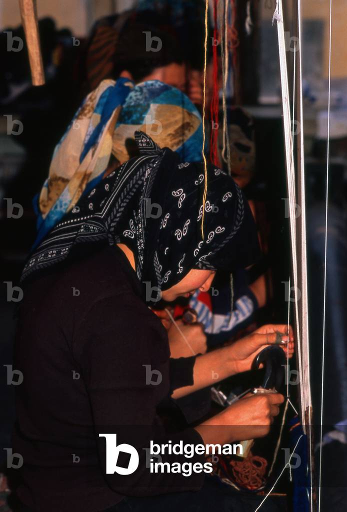 China: Uighur carpet weavers, carpet factory, Khotan, Xinjiang