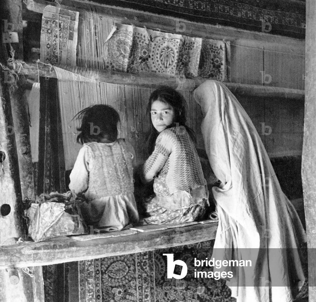 Iran/Persia: Rug-weaving woman with two young girls, Hamadan, c.1920