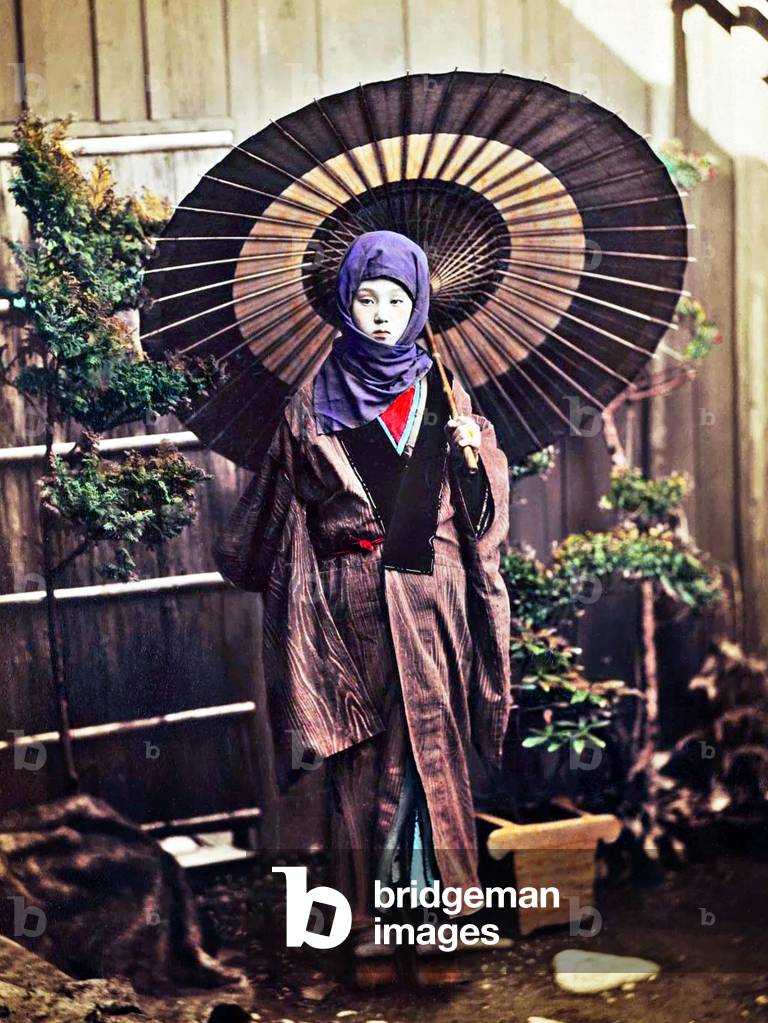 Japan: Japanese woman with parasol dressed for winter, 1890s
