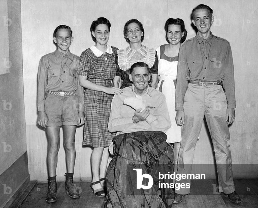 USA / Philippines: A smiling 'Pappy Gunn' (Colonel Paul Irvine) with his family recuperating from wounds from a white phosporous bomb dropped on the airfield at Tacloban, during the liberation of the Philippines, late 1945