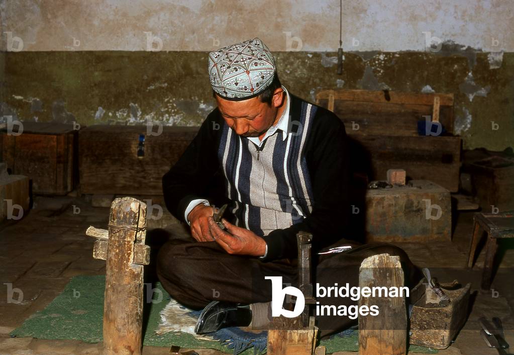 China: Crafting a highly decorative traditional hand-made knife in a small workshop in Yengisar, Xinjiang Province (photo)